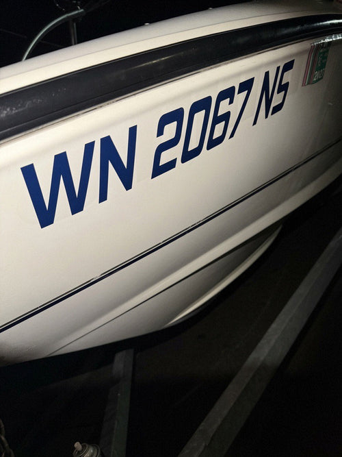 Washington boat registration numbers installed on a hull with current year validation tab