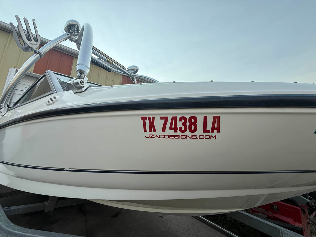 Red vinyl lettering applied to a boat hull side, clean edges and even spacing