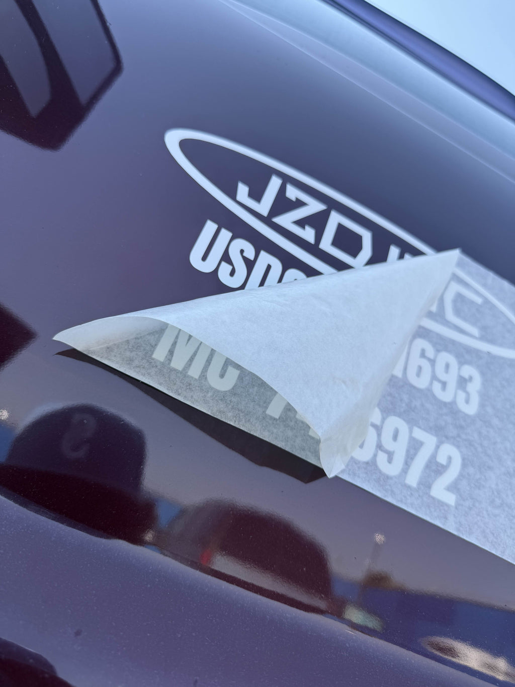 On-site install in progress - squeegee and transfer tape removal on a vehicle door