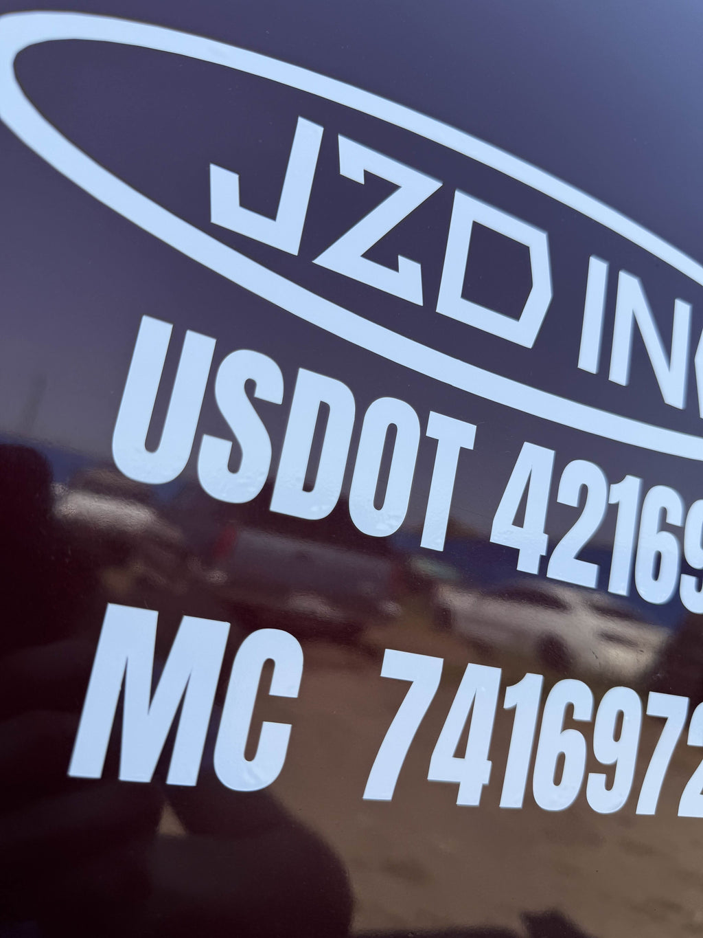 Finished vehicle door lettering with company name and compliance numbers, Spokane WA install