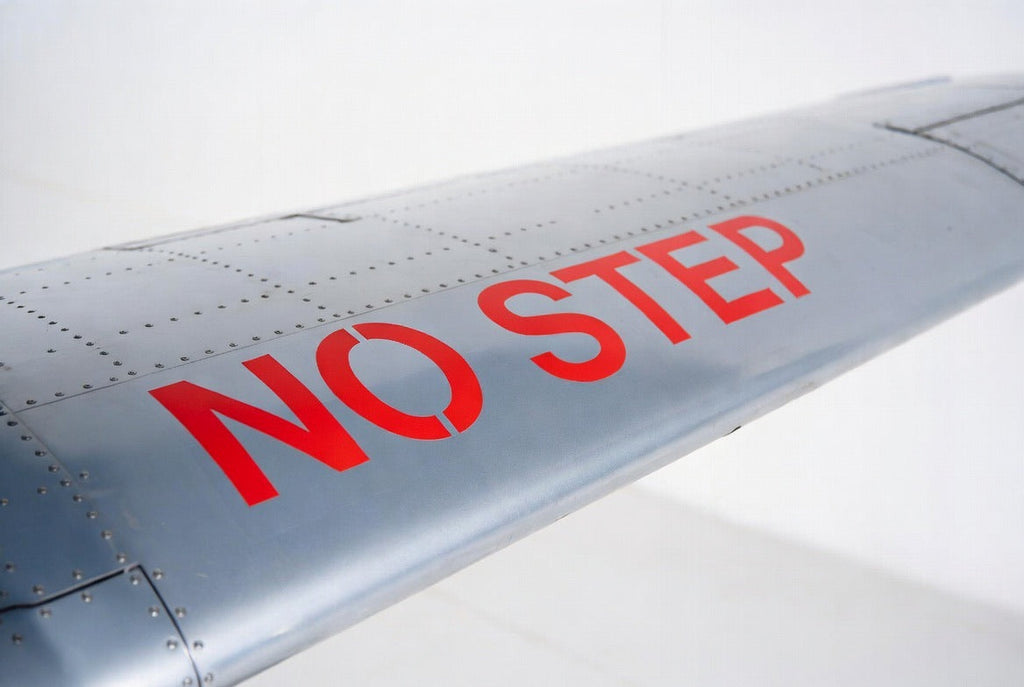NO STEP placard applied to a riveted bare aluminium wing