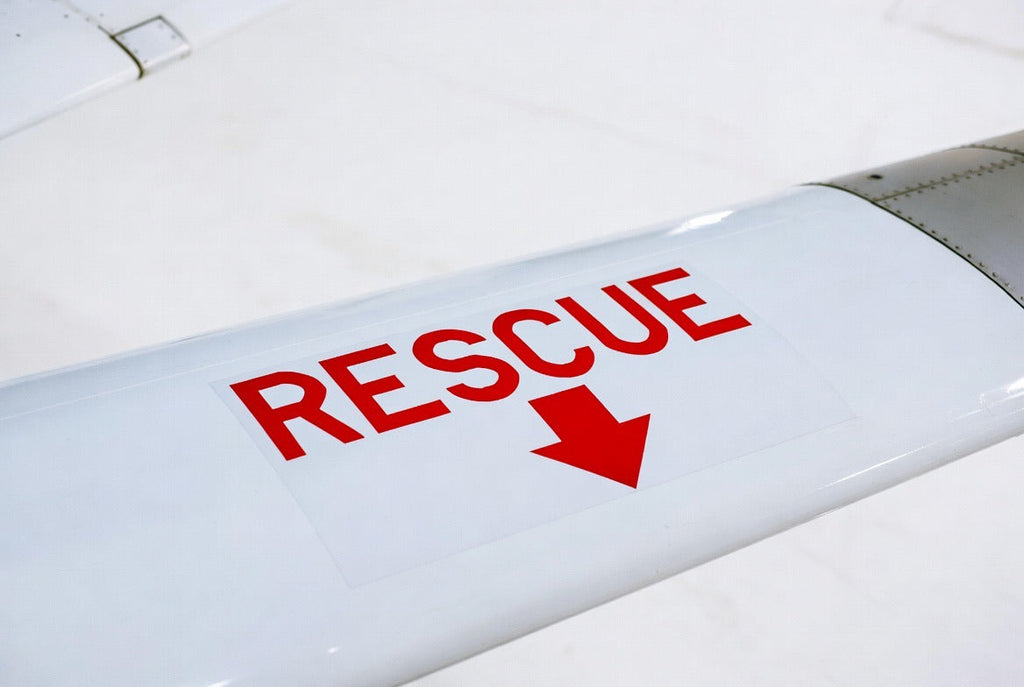 RESCUE placard with directional arrow applied to a white aircraft wing