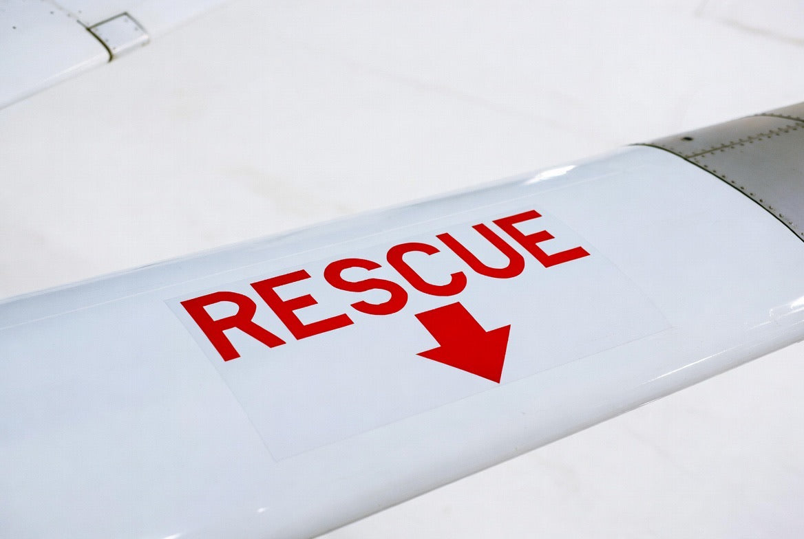 RESCUE placard with directional arrow applied to a white aircraft wing
