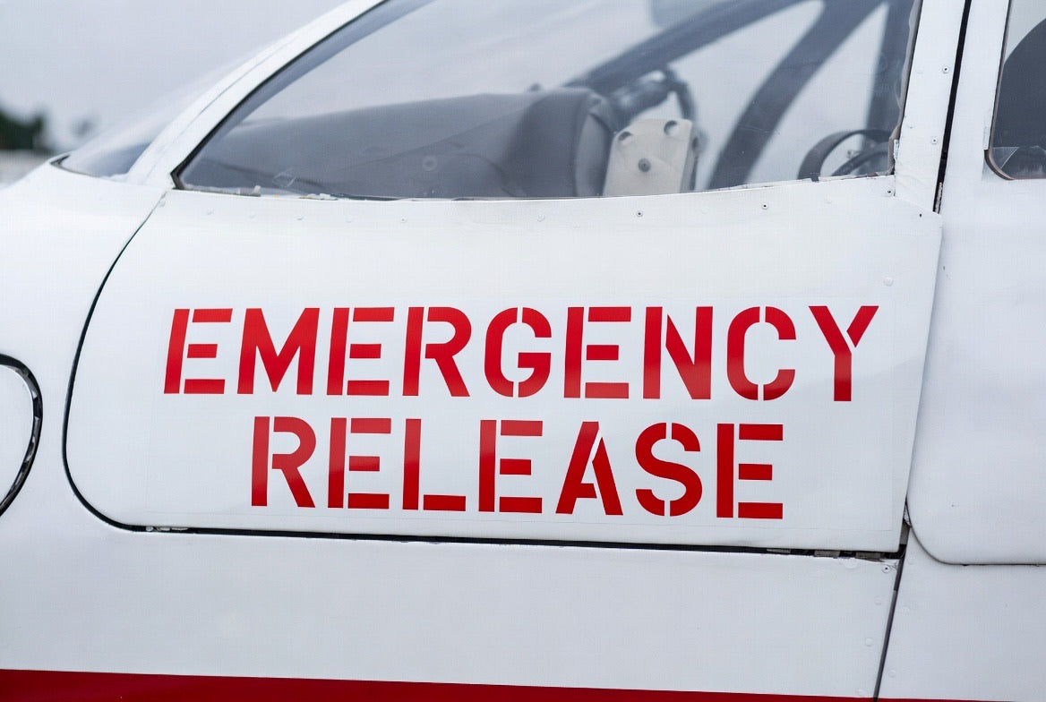 On-airport install - EMERGENCY RELEASE placard applied to an aircraft cockpit door