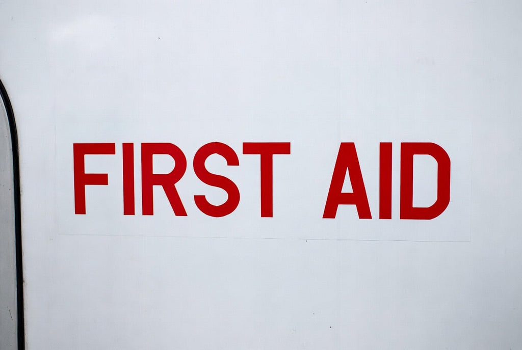 FIRST AID placard applied to a white aircraft cabin panel