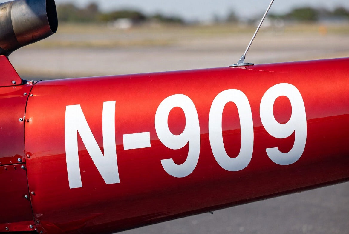 Helicopter N-number lettering in red vinyl on a tailboom